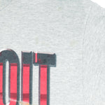 1990s vintage NHL Red Wings hockey puck T-Shirt by Fruit Of The Loom. Grey in color, with big spell-out, fits Large size and is in excellent condition