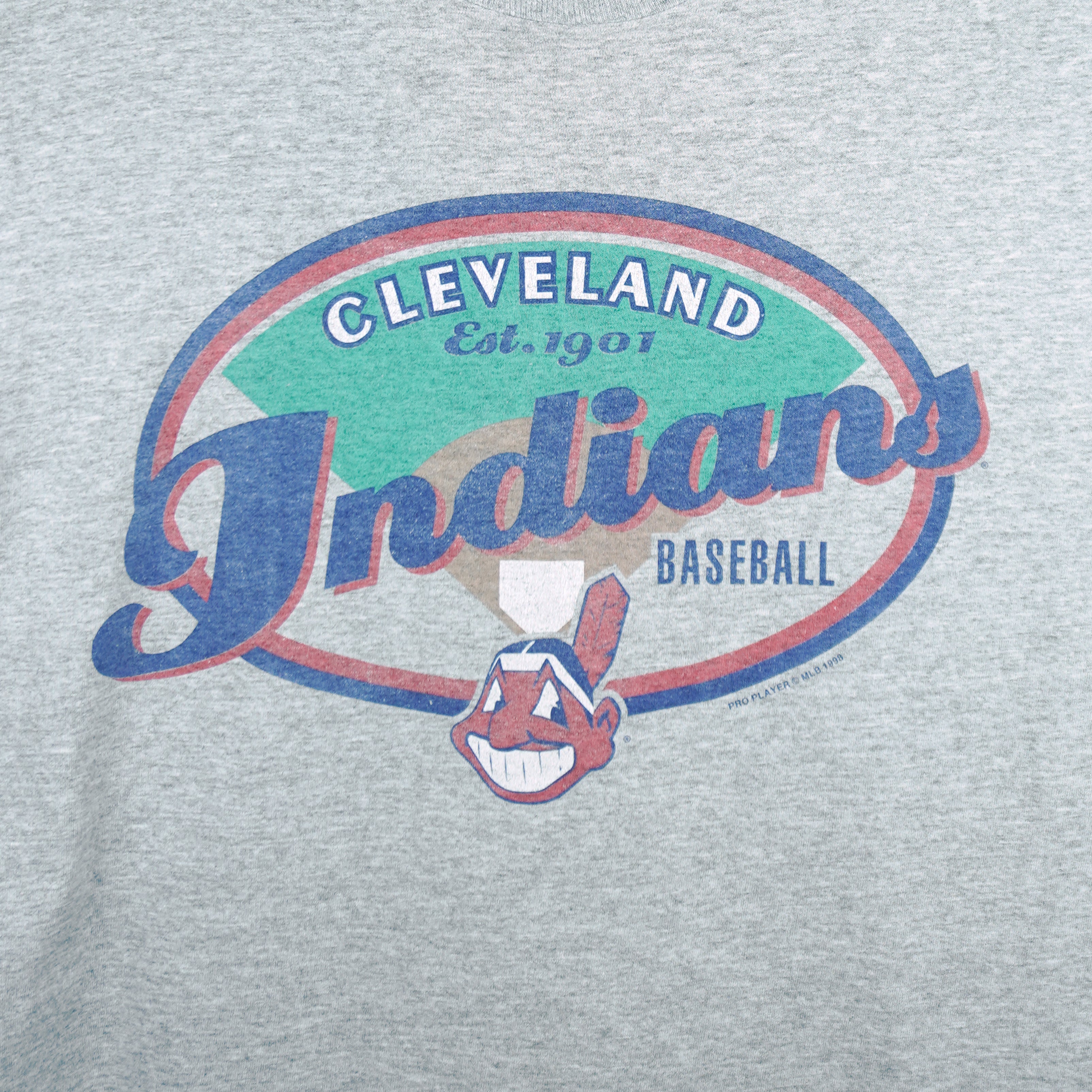 1998 vintage MLB Cleveland Indians T-Shirt by Pro Player. Grey in color with spell-out on front and Pro Player embroidered patch on left sleeve, Large in size and is in excellent condition.