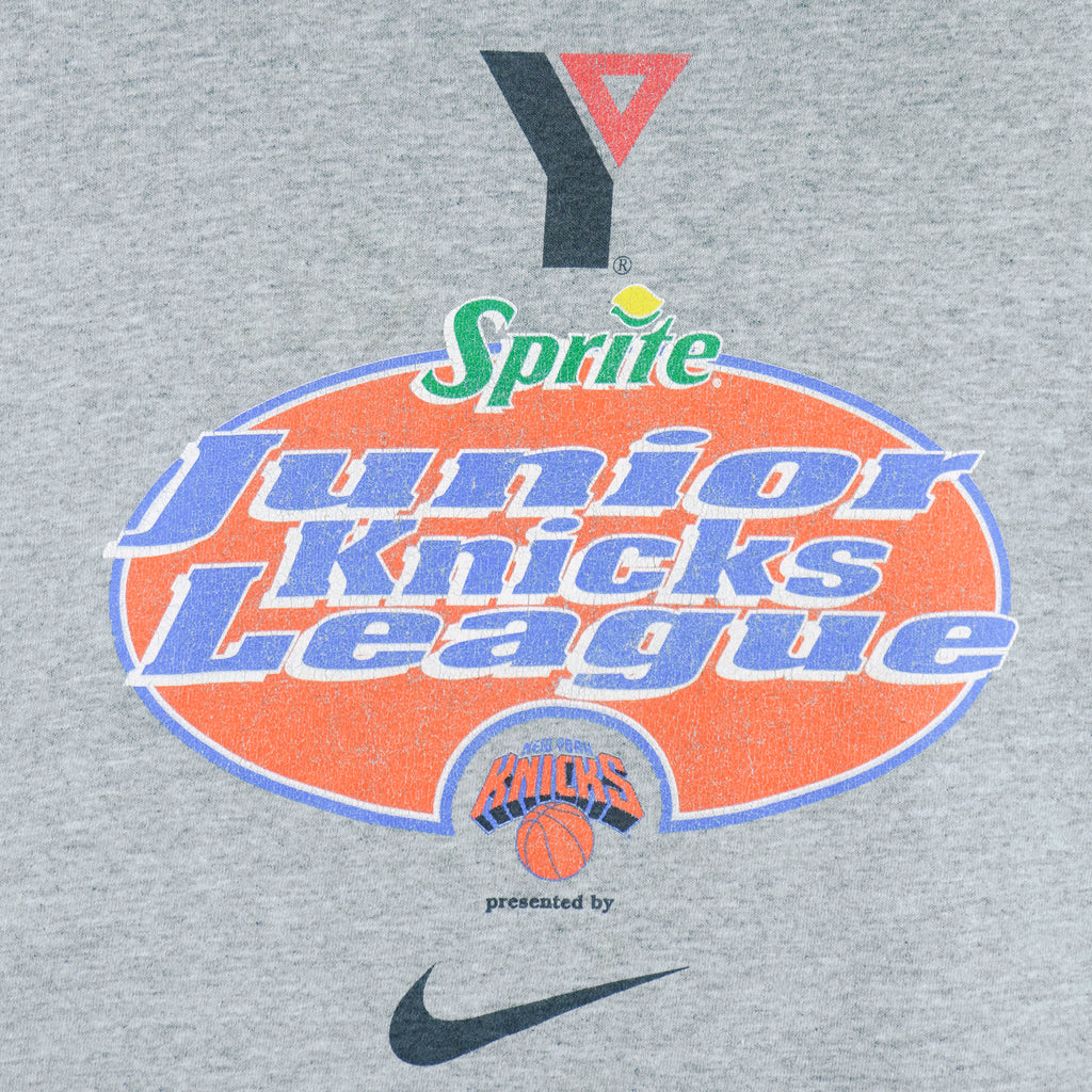 1990s vintage NBA New York Knicks Junior League T-Shirt from Jerzees. Grey in color with YMCA, Sprite, Knicks and Nike logos on front, Foot Locker logo on back, Large in size and is in excellent condition.