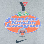 1990s vintage NBA New York Knicks Junior League T-Shirt from Jerzees. Grey in color with YMCA, Sprite, Knicks and Nike logos on front, Foot Locker logo on back, Large in size and is in excellent condition.