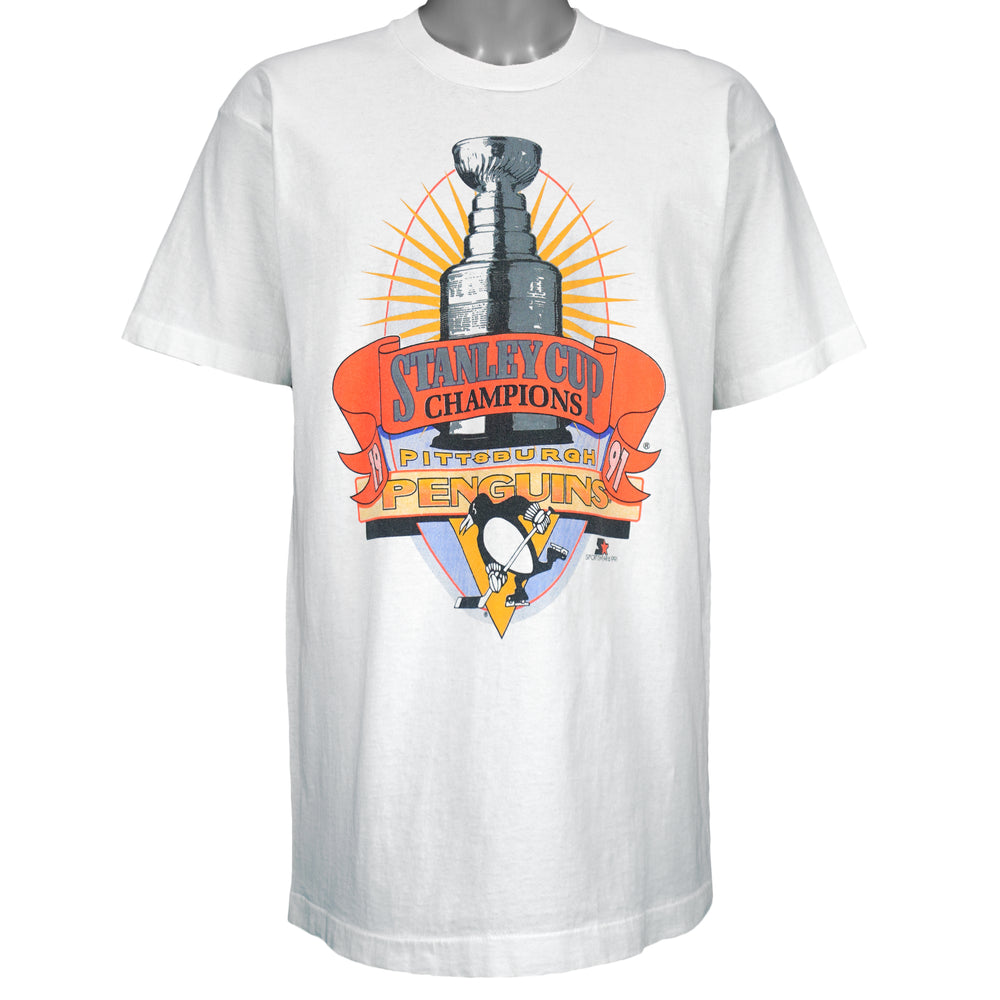 1991 vintage NHL Pittsburgh Penguins Stanley Cup Champions T-Shirt by Fruit of the Loom. White in color with large trophy print by Starter on front, fits a long Large in size and is in an excellent condition.