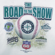2003 vintage MLB Seattle Mariners "Road to the Show" spell-out T-Shirt by Gildan. White in color with farm team logos (Everett Aquasox, Wisconsin Timber Rattlers, Inland Empire 66ers of San Bernardino, San Antonio Missions, Tacoma Rainiers), Medium in size and is in excellent condition.