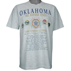 1990s vintage Oklahoma "The Sooner State" T-Shirt by Fruit of the Loom. Grey in color with various state facts and history printed on front, Large in size and is in excellent condition.