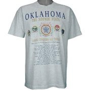 1990s vintage Oklahoma "The Sooner State" T-Shirt by Fruit of the Loom. Grey in color with various state facts and history printed on front, Large in size and is in excellent condition.