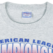 2000 vintage MLB Mariners Vs Yankees American League Championship T-Shirt by All Sport. Grey in color with big spell-out and baseball caps printed graphic, X-Large in size and is in excellent condition.