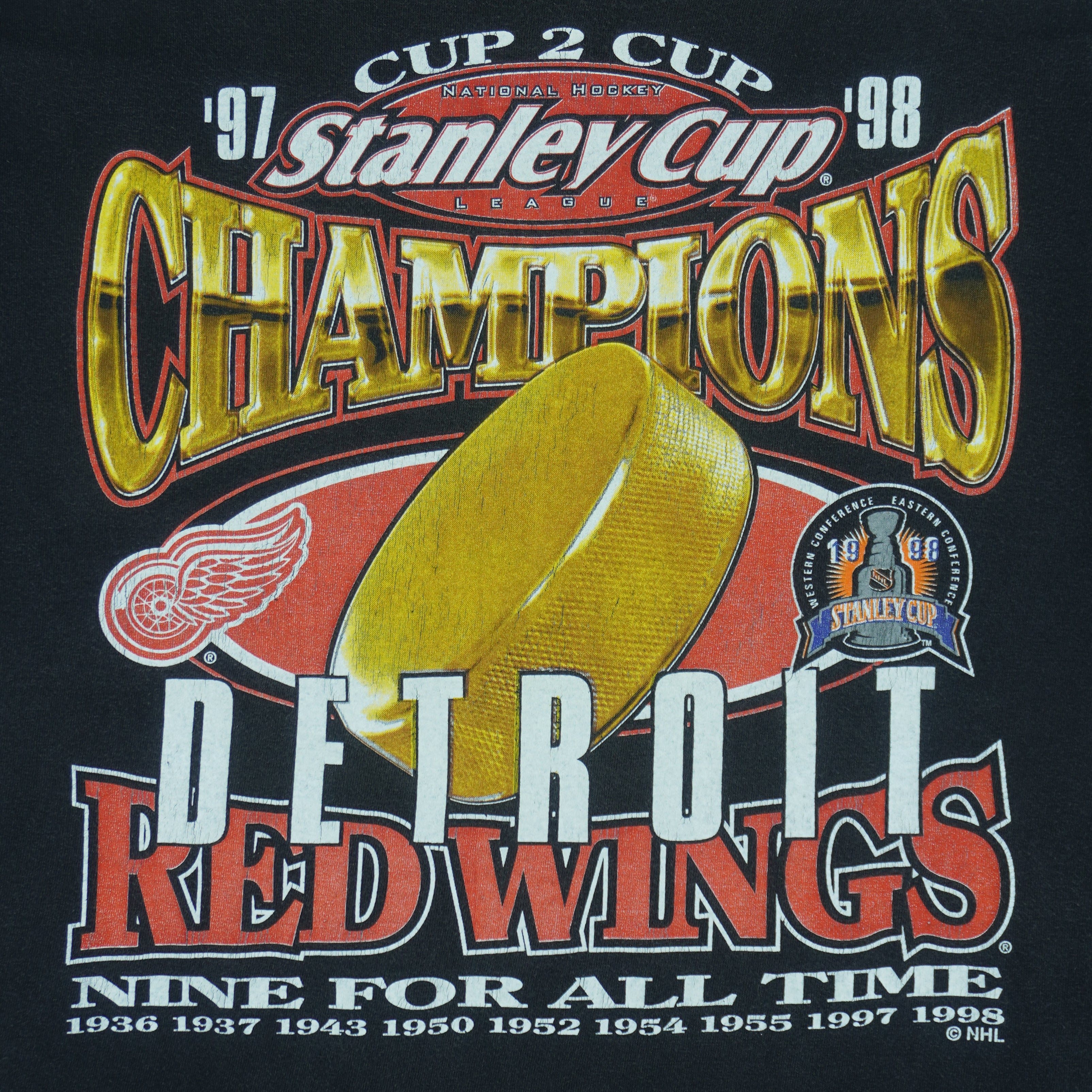 1998 vintage NHL Detroit Red Wings Stanley Cup Champions 97-98 T-Shirt by Logo 7. Black in color with big printed graphic and spell-out on front: Cup 2 Cup, Nine for All Time. Large in size and is in excellent condition.