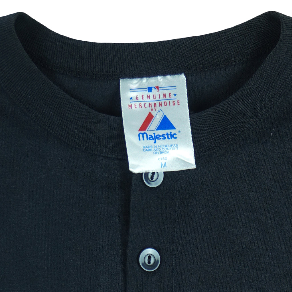 1990s vintage MLB Chicago White Sox button-collar T-Shirt by Majestic - Genuine Merchandise. Black in color with big logo on front, #10 on back, Majestic logo on right sleeve and Qdoba Mexican Grill logo on left sleeve, medium in size and is in very good condition.