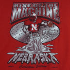 2004 vintage NCAA University of Nebraska-Lincoln Cornhuskers spell-out Gildan T-Shirt. Red in color with "Rise of the Machine, West Coast Offense" text and football player graphic on front by Art-Fx Collectors Edition. X-Large in size and in excellent condition.