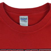 2004 vintage NCAA University of Nebraska-Lincoln Cornhuskers spell-out Gildan T-Shirt. Red in color with "Rise of the Machine, West Coast Offense" text and football player graphic on front by Art-Fx Collectors Edition. X-Large in size and in excellent condition.