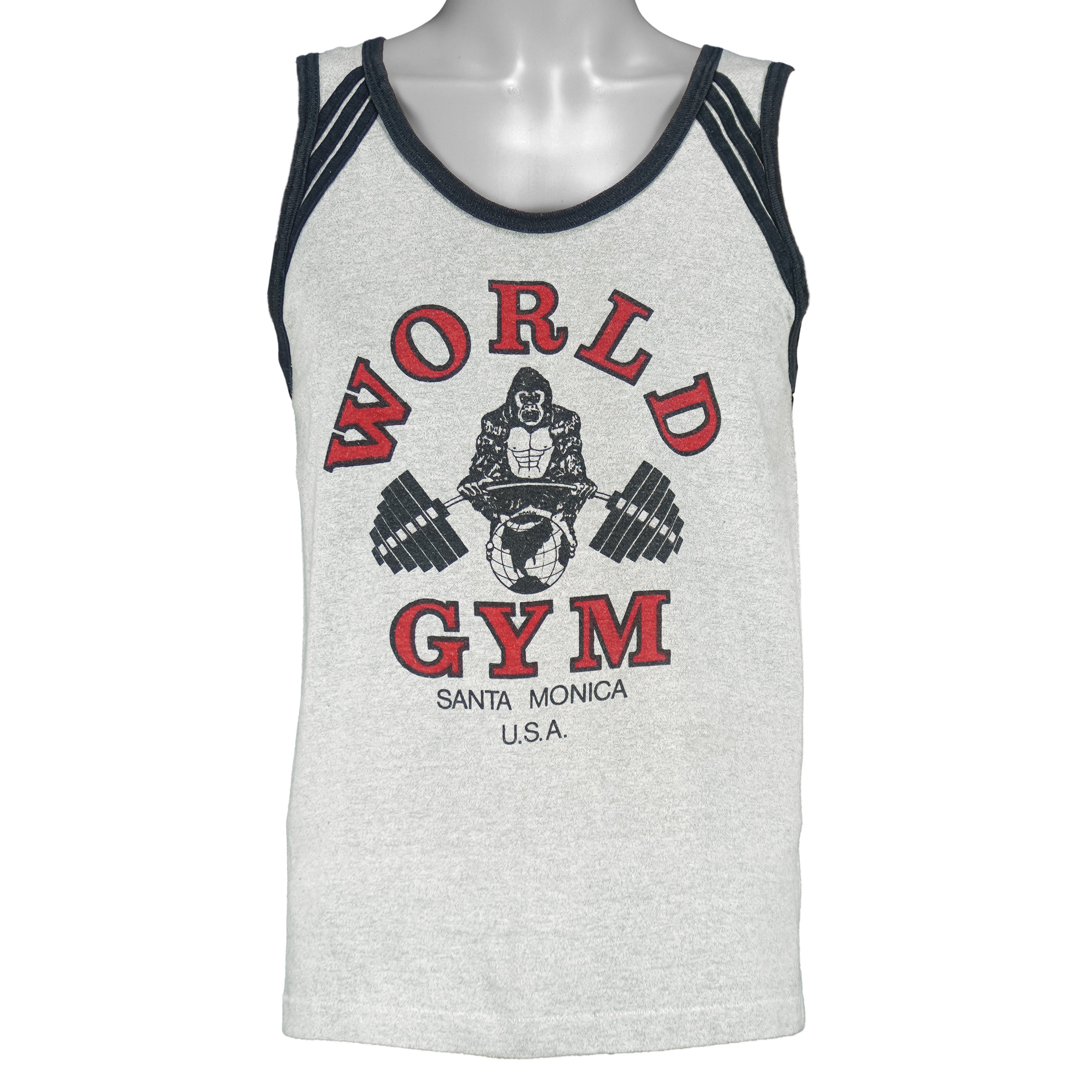 1990s vintage World Gym, Santa Monica USA sleeveless workout shirt. Grey in color with black trim, has a big printed graphic of the gorilla logo on front and back, fits Medium in size, and is in excellent condition.