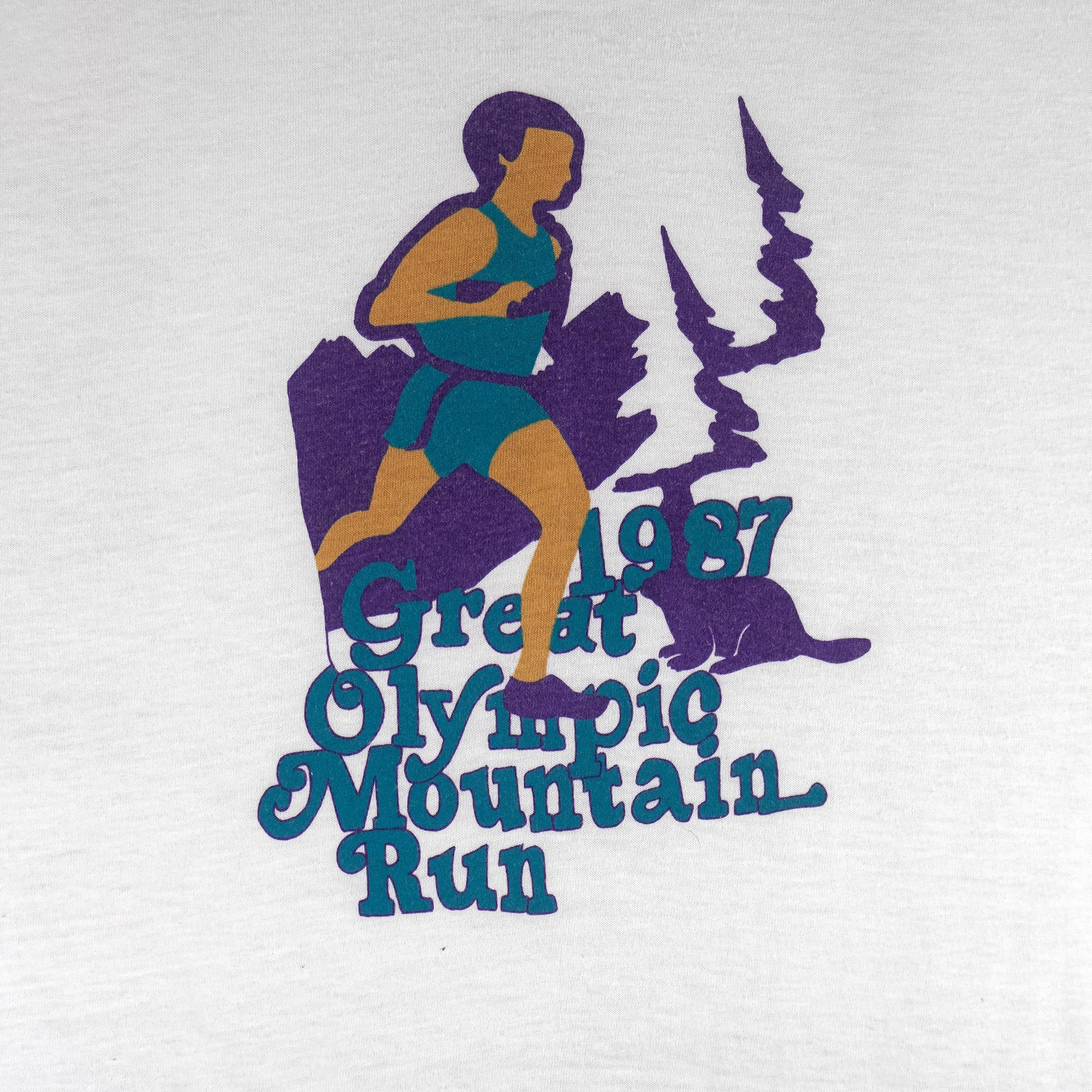 1987 vintage Great Olympic Mountain Run T-Shirt by My Shirt is Made in the USA. White in color with printed graphic on front, tagged size Large, and is in excellent condition.