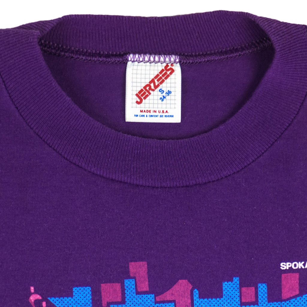 1991 vintage Bloomsday, Spokane Washington, Finisher T-Shirt by Jerzees. Purple in color with abstract people and skyline graphic printed on front and Nike insignia on left sleeve, tagged size Small and is in excellent condition.