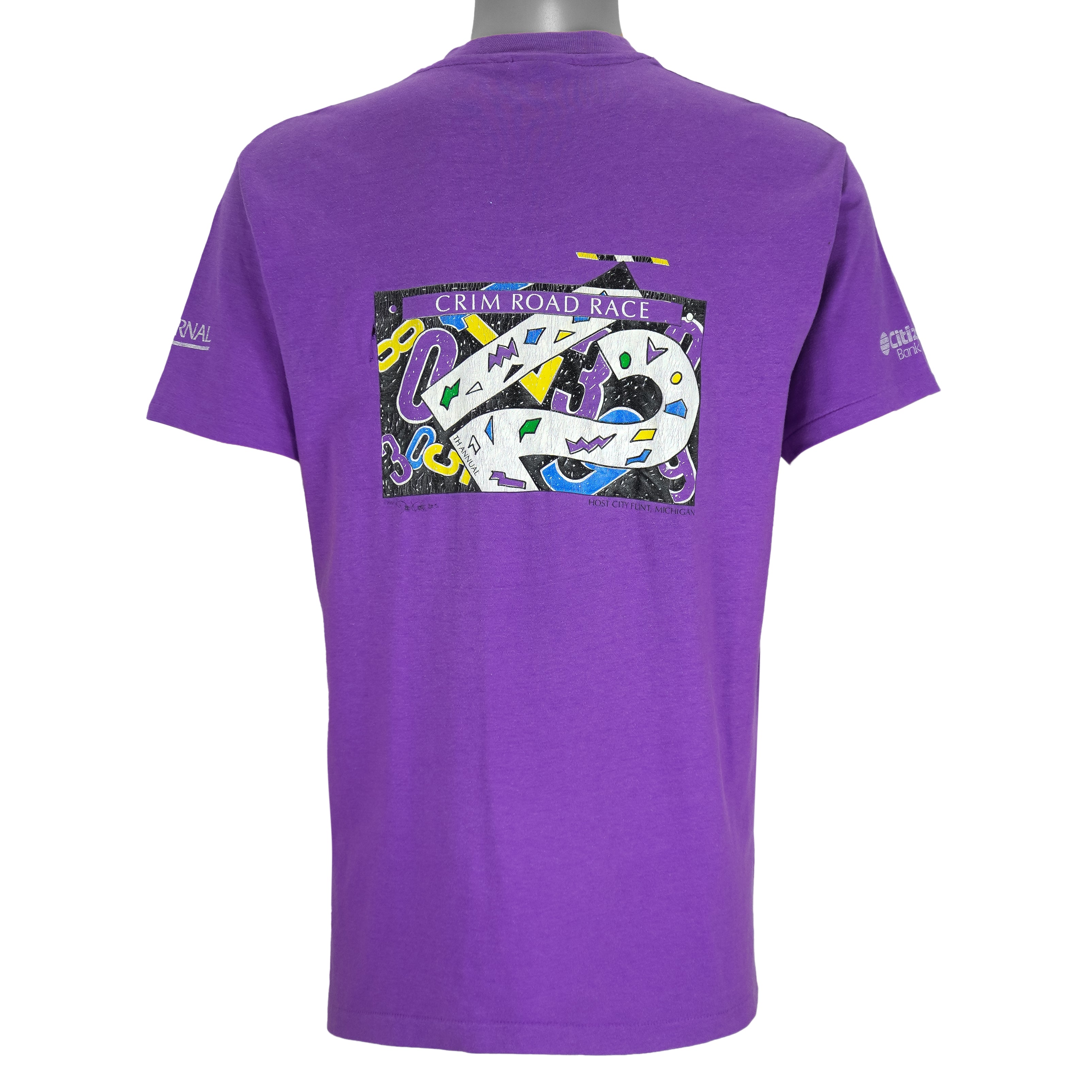 1988 vintage Flint Michigan 8 KM Crim Road Race T-Shirt by Hanes. Purple in color with printed&nbsp; graphics on front and back, tagged size Large and is in excellent condition.