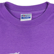 1988 vintage Flint Michigan 8 KM Crim Road Race T-Shirt by Hanes. Purple in color with printed&nbsp; graphics on front and back, tagged size Large and is in excellent condition.