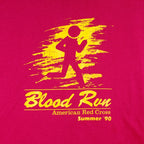 1990 vintage American Red Cross Blood Run, Wichita region, T-Shirt by Hanes. Pink in color with printed graphics on front and back, tagged size X-Large, and is in excellent condition.
