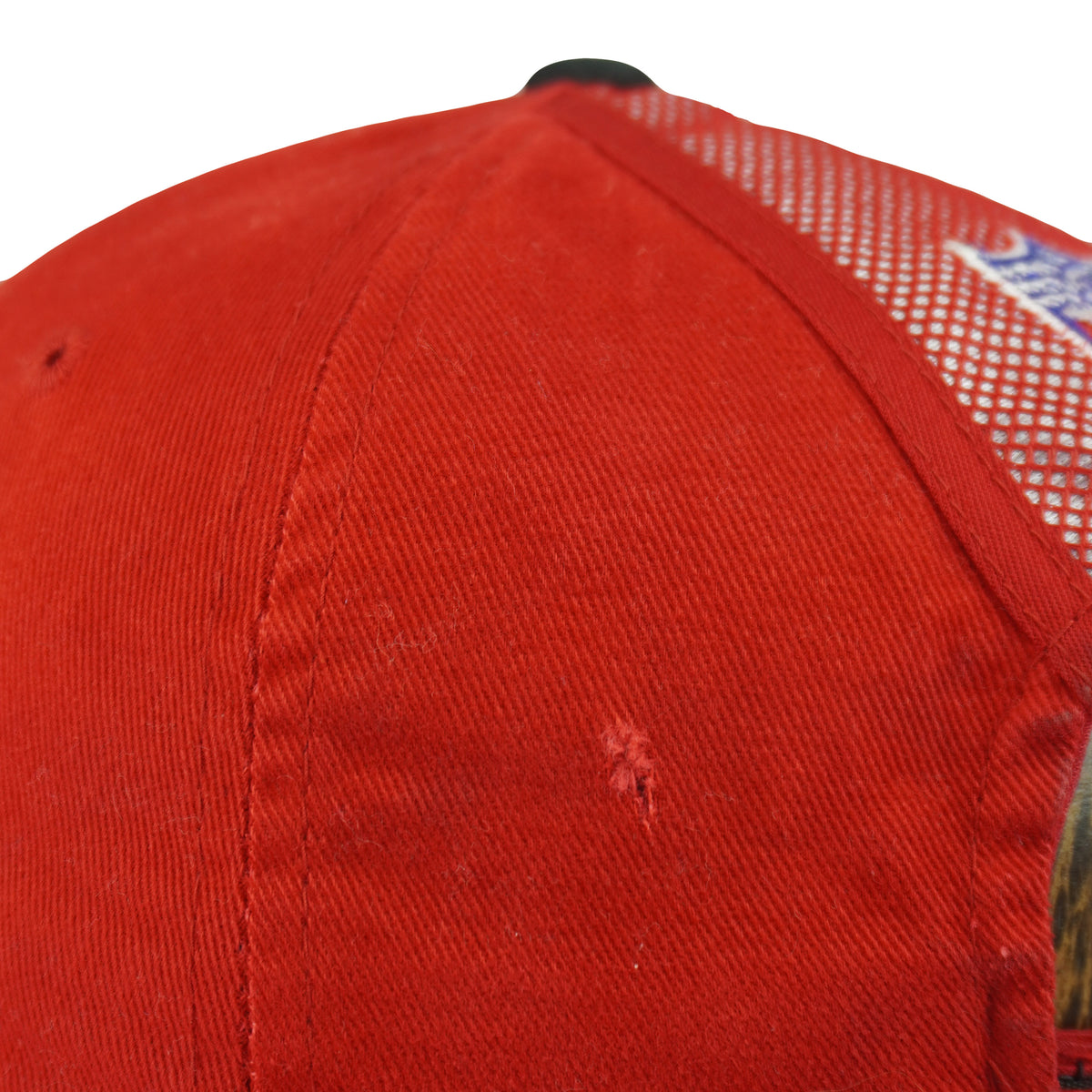 Small frayed tear on a side panel of the red crown