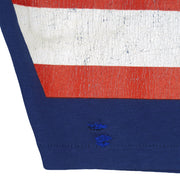 Two small stitched sleeve repairs beneath cracked red and white print