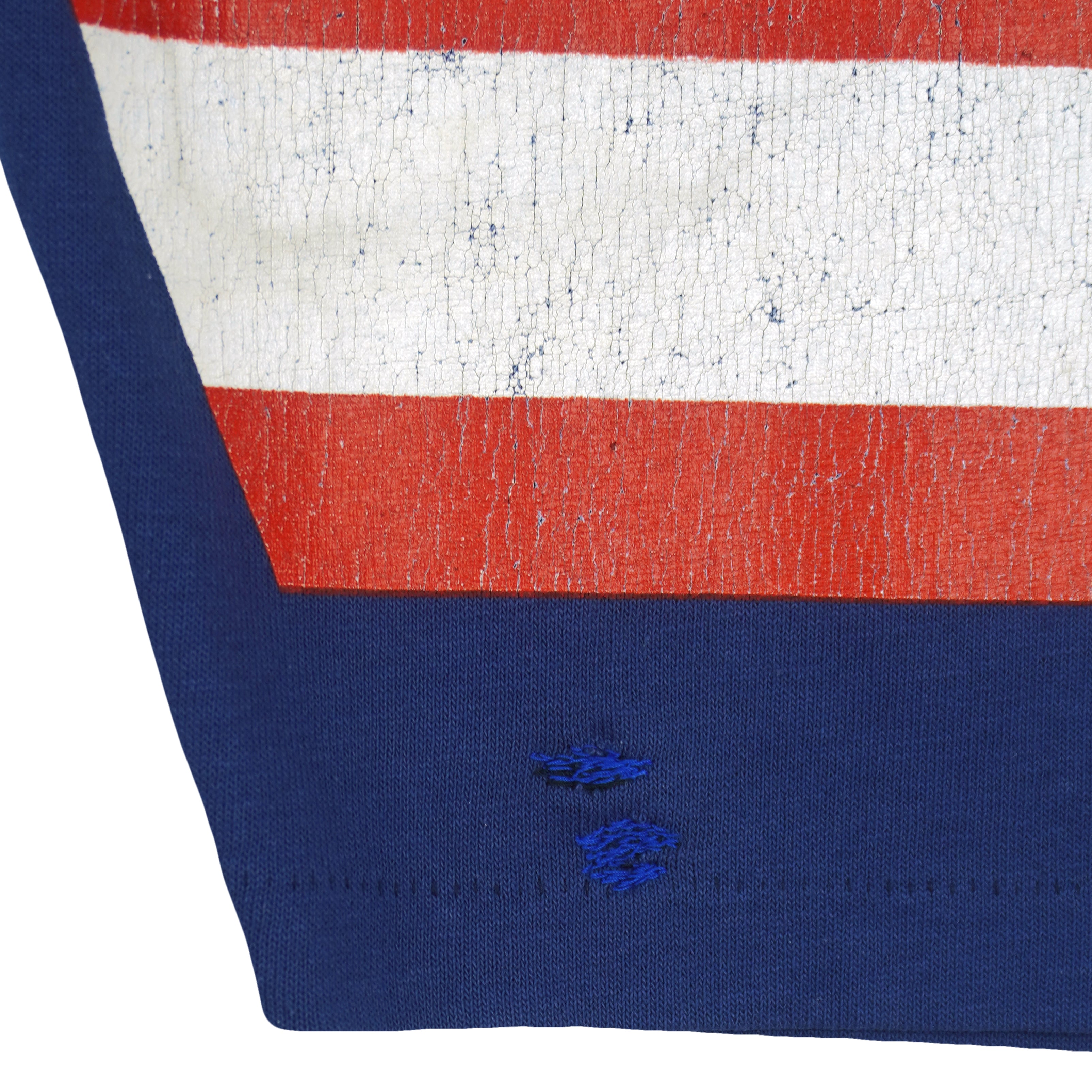 Two small stitched sleeve repairs beneath cracked red and white print