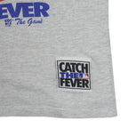 Catch the Fever patch near the gray shirt hem