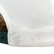 Small mark beside the rear opening of the white hat