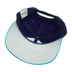 Interior and pale underbrim view of the blue, teal, and white Seattle Mariners compass-logo snapback cap