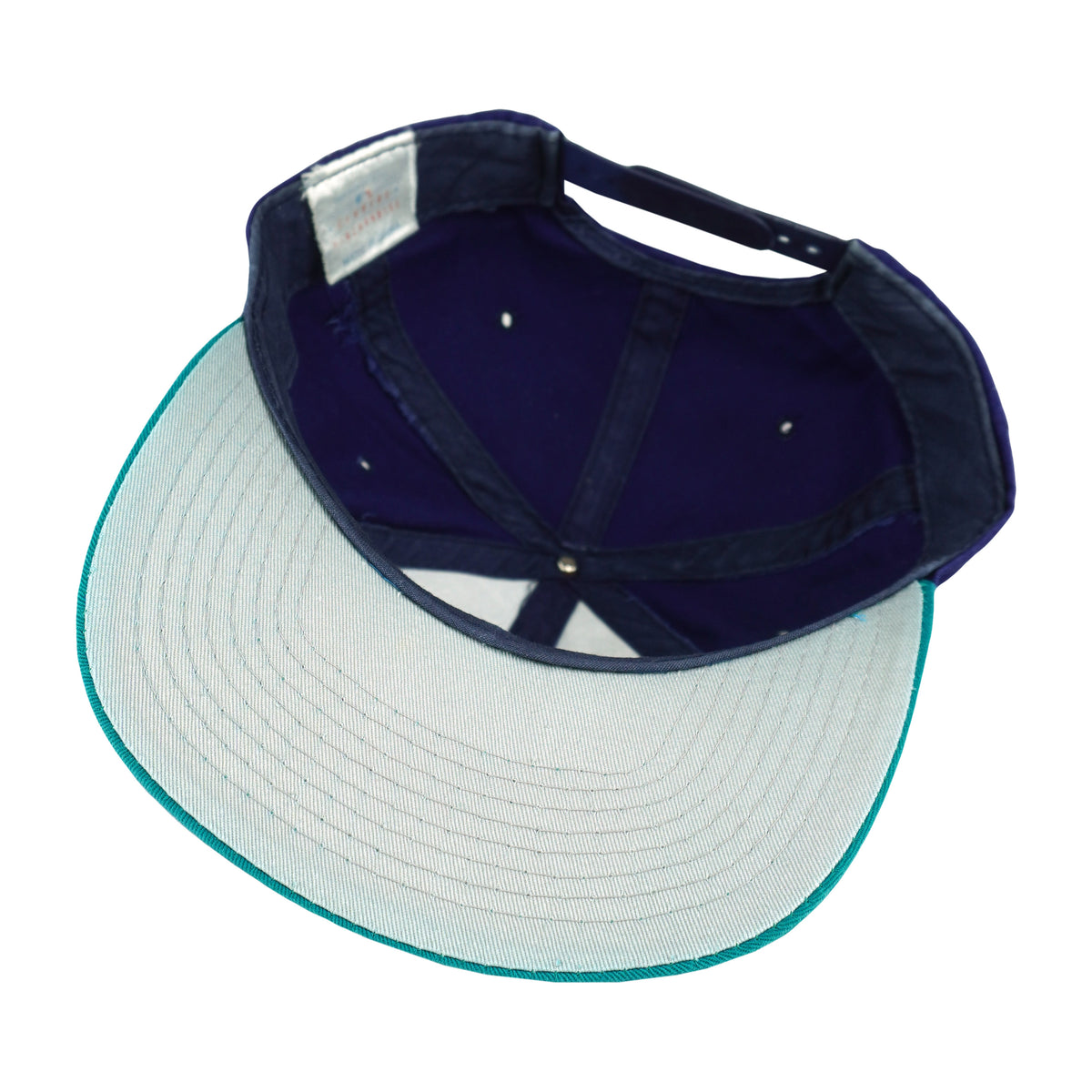 Interior and pale underbrim view of the blue, teal, and white Seattle Mariners compass-logo snapback cap