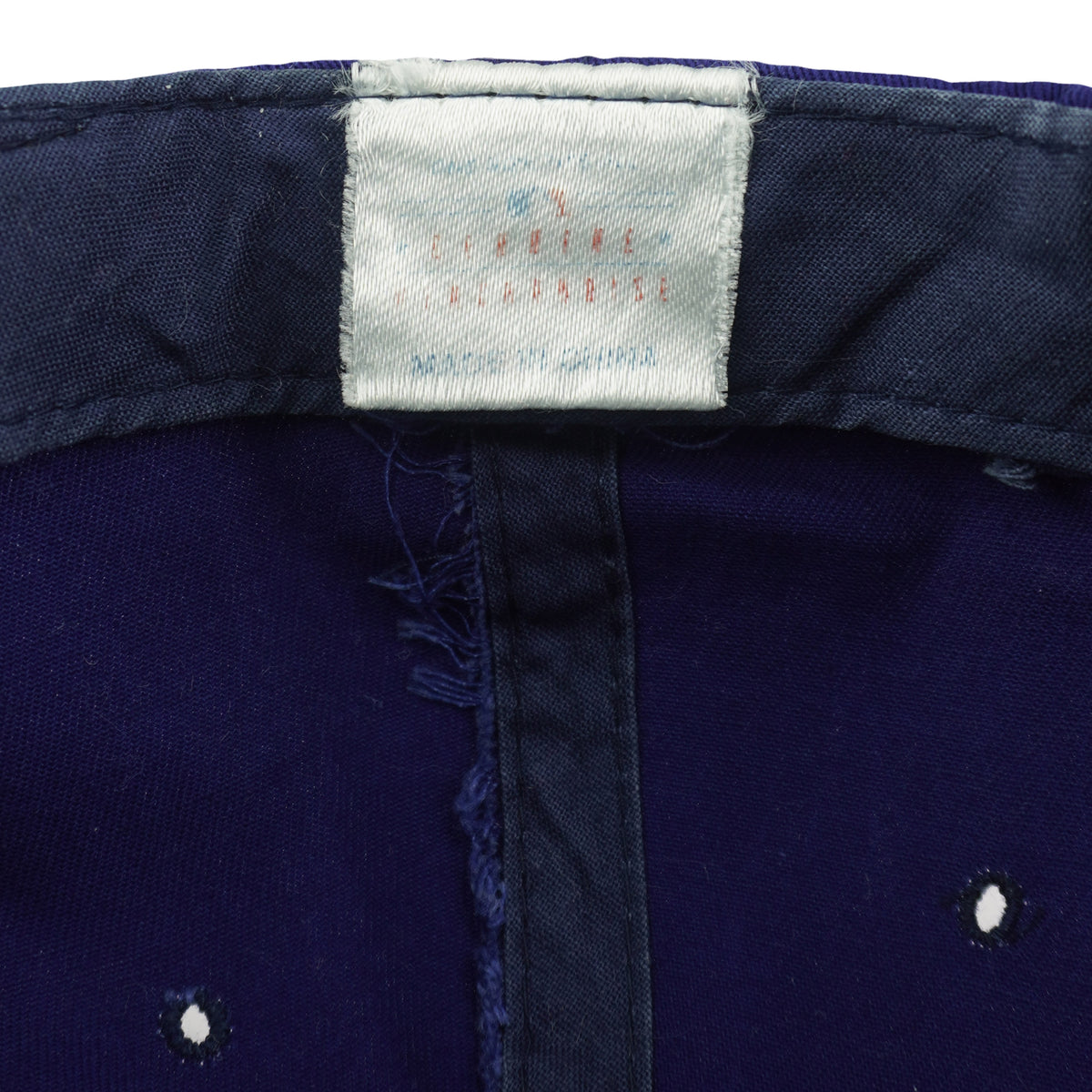 Close view of a faded white interior label inside the blue Seattle Mariners snapback cap