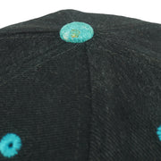 Top-button wear detail of the black and teal New Orleans Bourbon Street snapback cap