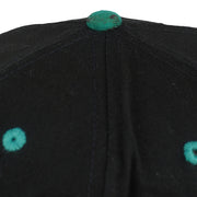 Close view of discoloration on the teal top button of the black Dolphins cap