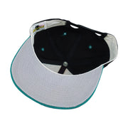 Interior and white underbrim view of the black, teal, and white Miami Dolphins segmented-logo snapback cap
