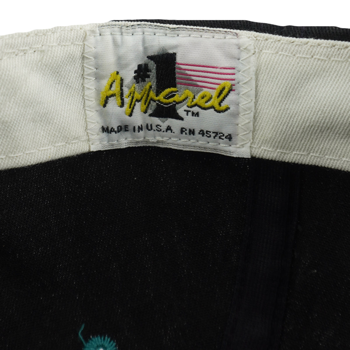 Number-one Apparel label detail of the black, teal, and white Miami Dolphins segmented-logo snapback cap