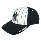 Angled Yankees cap showing white front panels, dark side panels and brim lettering