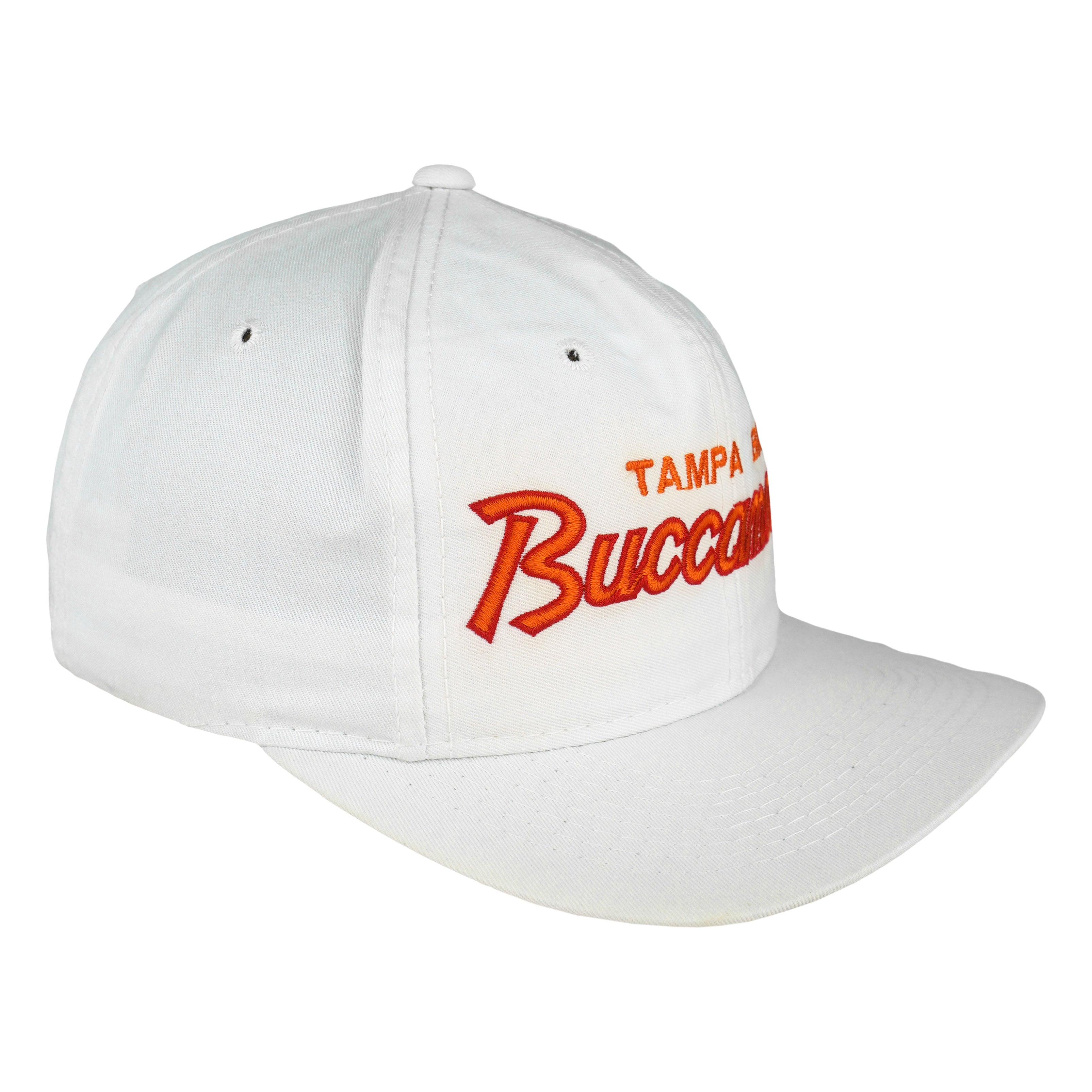 Angled white Buccaneers cap showing orange script embroidery and curved brim