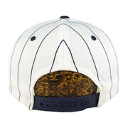 Rear of the white New York Yankees cap with navy stripes, navy eyelets, and a dark plastic snap