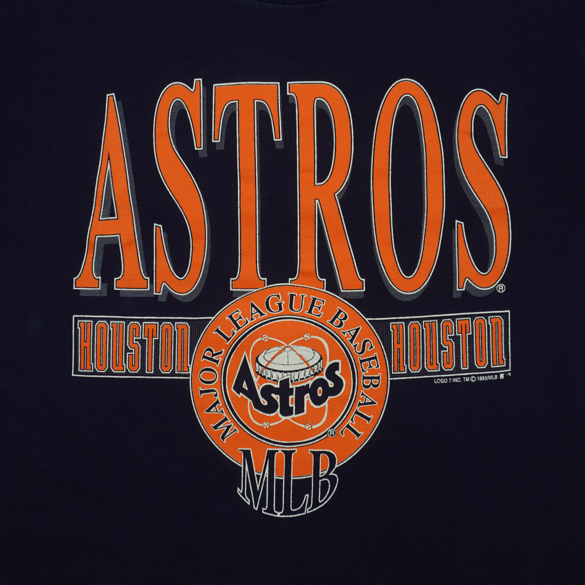 Close view of orange Astros lettering and the circular Major League Baseball graphic