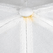 Close-up of yellowing around the top button on the white Bears cap