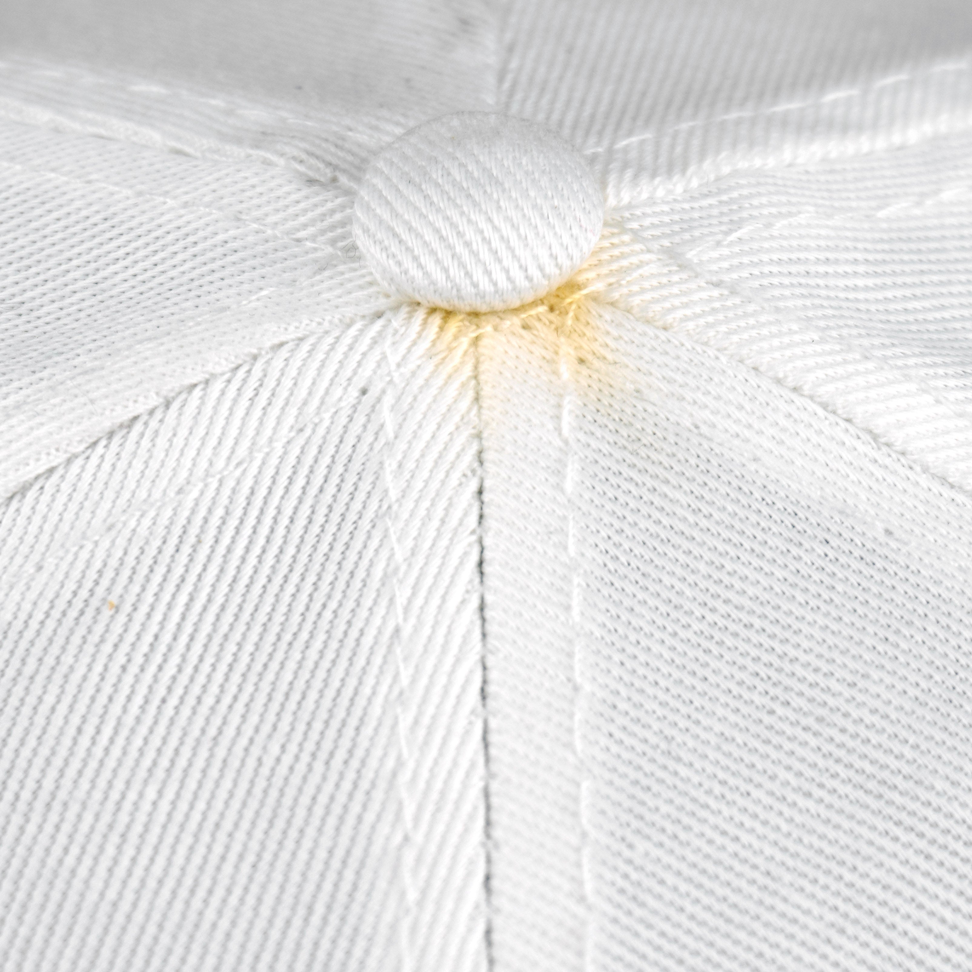 Close-up of yellowing around the top button on the white Bears cap