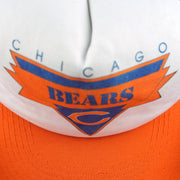 Close view of Chicago Bears lettering and the orange C logo on the white cap front