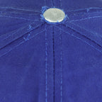 Close view of fraying and surface fading around the blue top button on the Pistons cap
