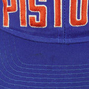 Detailed view of the Pistons front embroidery and royal blue stitched brim