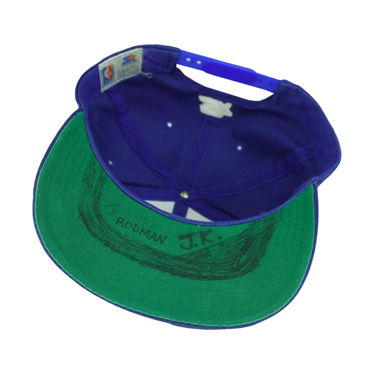Interior of the Detroit Pistons cap showing black markings across the green underbrim