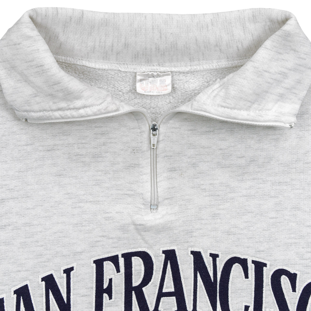 Close-up of the faded neck label and gray quarter-zip collar construction