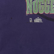 Close-up of dark marks and small holes below the Denver Nuggets logo