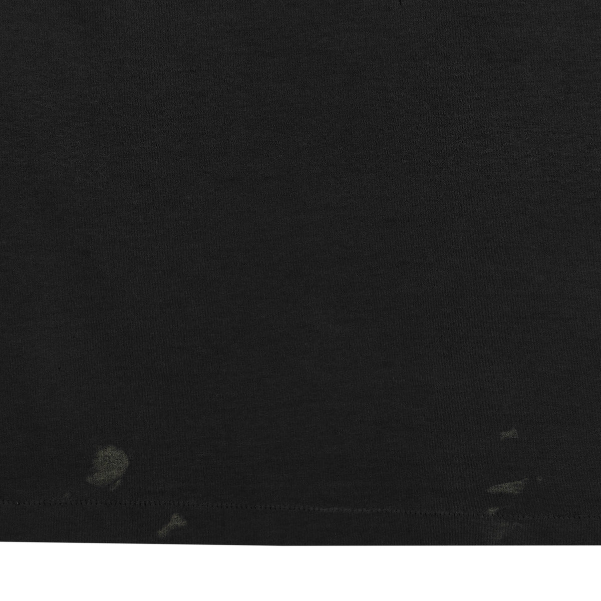 Close-up of several faded marks near the lower hem of the black tour T-shirt