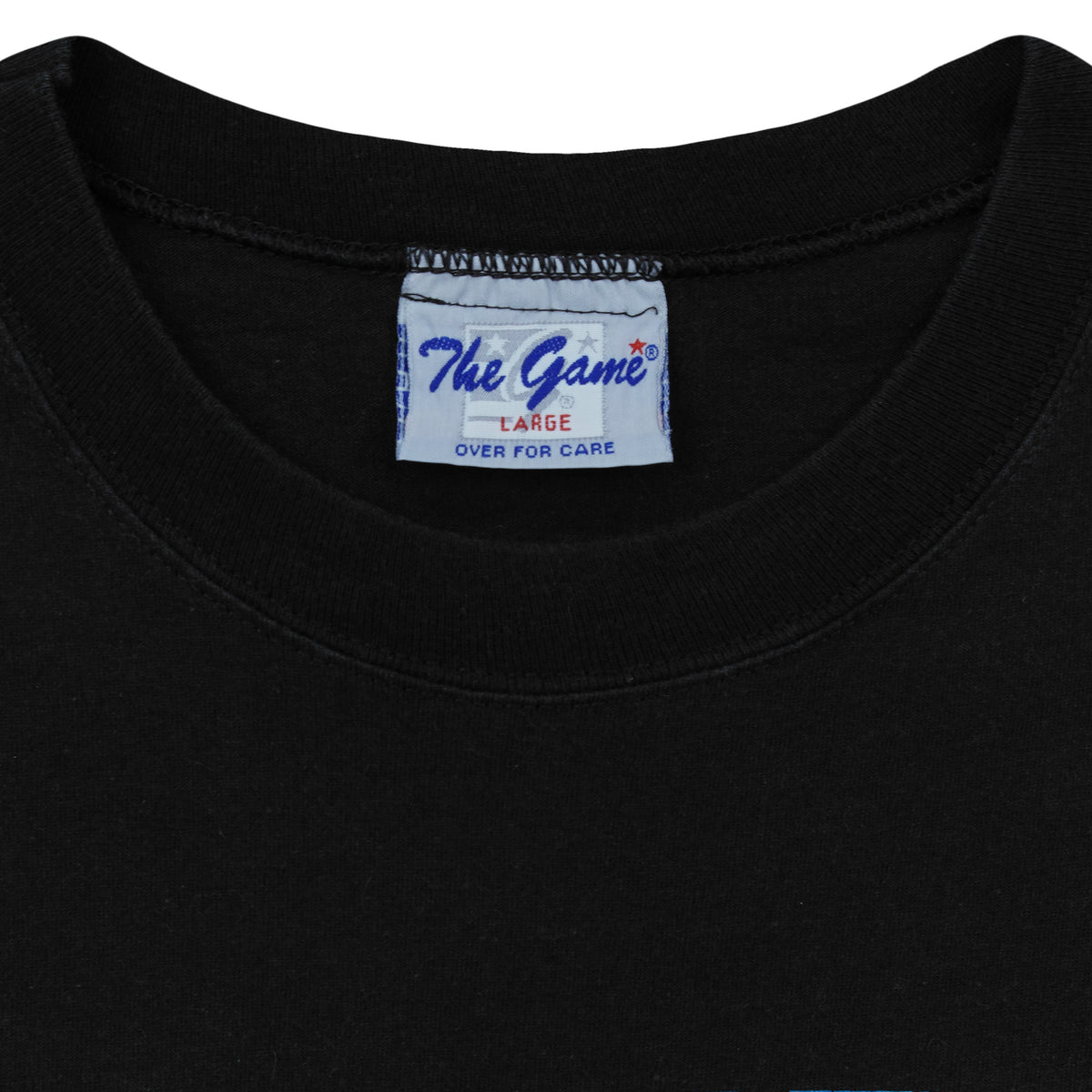 Close-up of the The Game neck label showing size L inside the black 1995 T-shirt.