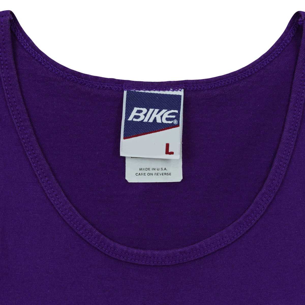 Close-up of the Bike neck label showing size L inside the purple 1995 tank top.