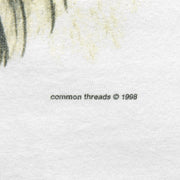 Close-up of the Common Threads seal pup print showing the 1998 copyright line on white fabric.
