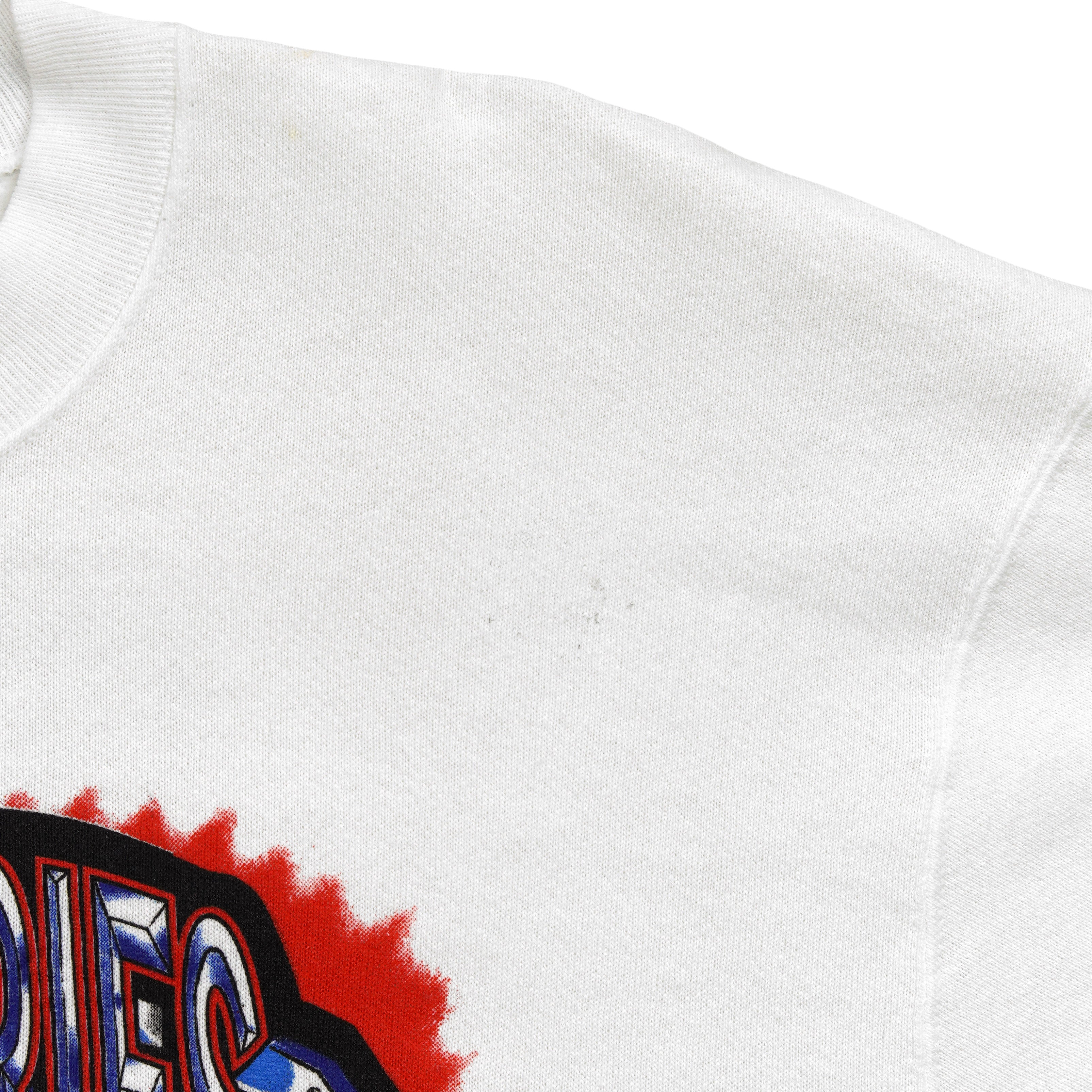 Close view of a small mark on the white sweatshirt shoulder