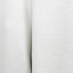 Close-up of a small hole and mark on the white sweatshirt fabric.