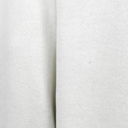 Close-up of a small hole and mark on the white sweatshirt fabric.